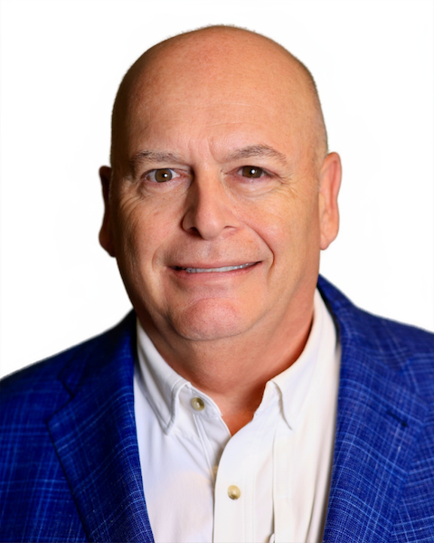 Guy Legare in a white button down shirt and blue sport coat