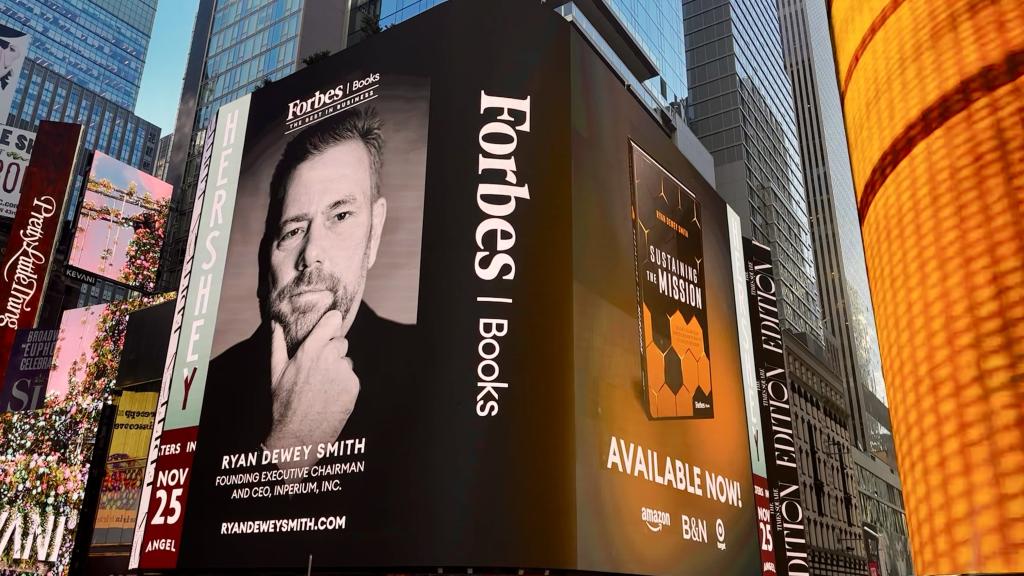 Ryan Dewey Smith's headshot and Sustaining the Mission book cover displayed on large screen in New York's Times Square