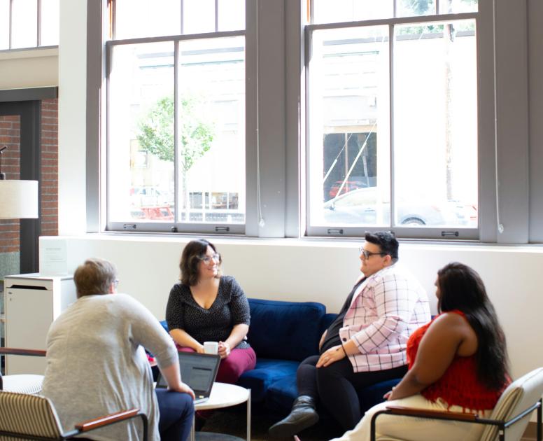 Four people in armchairs having a conversation or group therapy